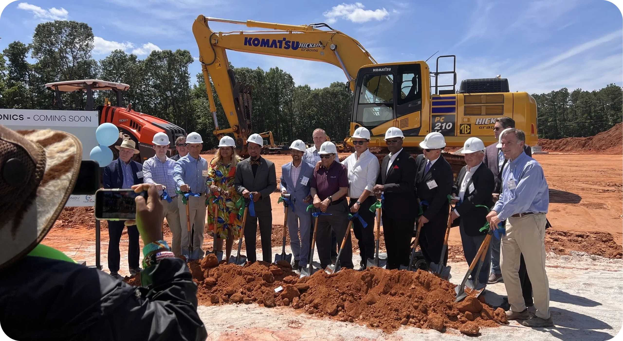 Community leaders holding a groundbreaking ceremony with shovels at a construction site.
